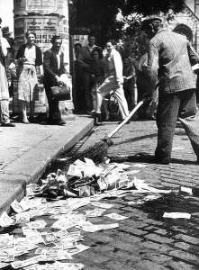 Sweeping worthless pengő banknotes from the street in Budapest. 